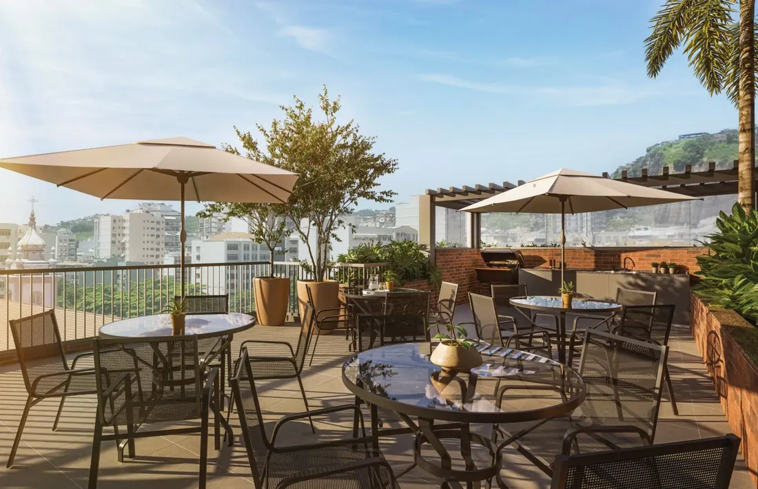 Rooftop com churrasqueira, mesas e ombrelones do Cores da Tijuca